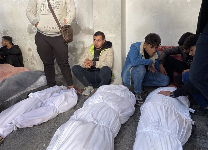 Palestinos junto a los cadáveres de varios muertos en ataques del Ejército de Israel tras ser trasladados al Hospital Baptista Al Ahli de la ciudad de Gaza, en el norte de la Franja de Gaza (archivo)