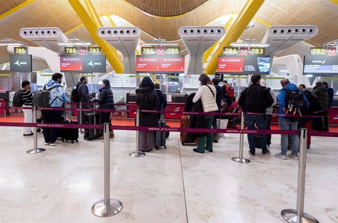 Archivo - Varias personas frente a la cola de facturación en el Aeropuerto Adolfo Suárez-Madrid Barajas