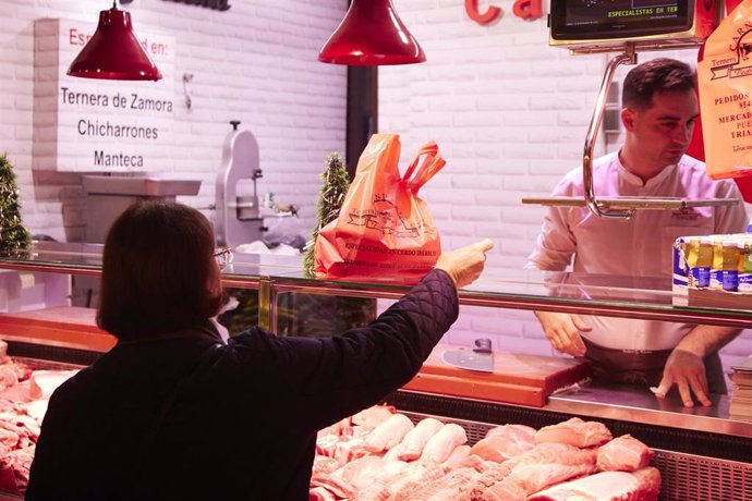 Archivo - Imagen de archivo de una señora realiza el pago de las compras en el Mercado de Abastos antes de la Navidad, a 23 de diciembre de 2022 en Sevilla (Andalucía, España). 