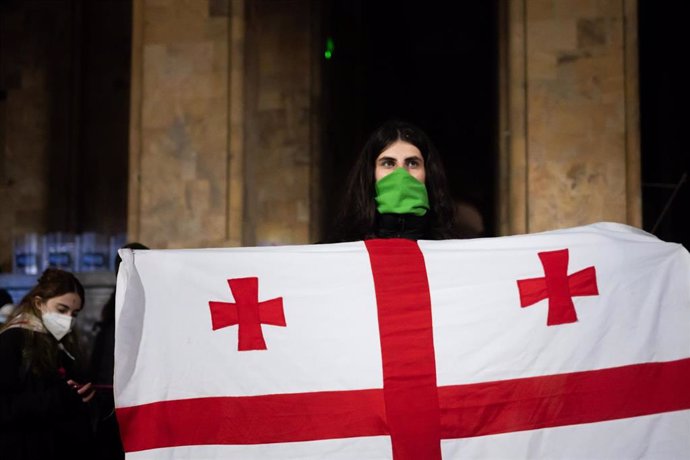 Una manifestante sostiene una bandera de Georgia en una protesta contra el Gobierno en Tiflis