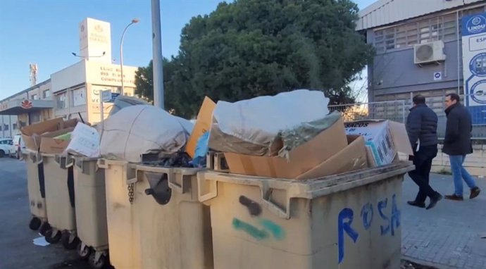 Contenedores desbordados de basura a plena luz del día.