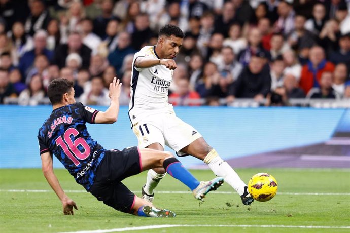 Archivo - El delantero del Real Madrid Rodrygo Goes dispara frente a Jesús Navas,del Sevilla FC, en el Santiago Bernabéu. 