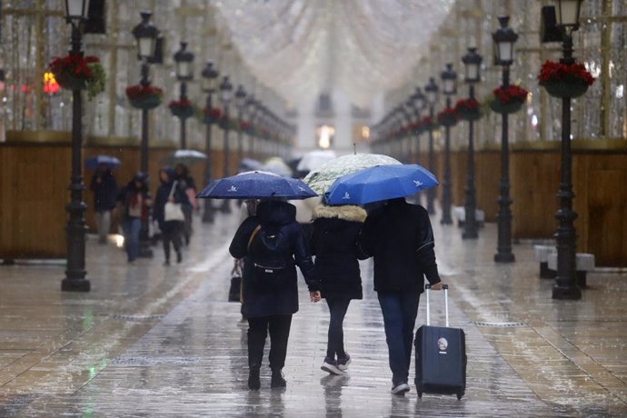 Gente con paraguas por las calles de Málaga. A 12 de diciembre de 2024 en Málaga, Andalucía (España). La Agencia Estatal de Meteorología (Aemet) ha activado avisos naranja en Costa del Sol-Guadalhorce y la Axarquía debido a lluvias intensas previstas para