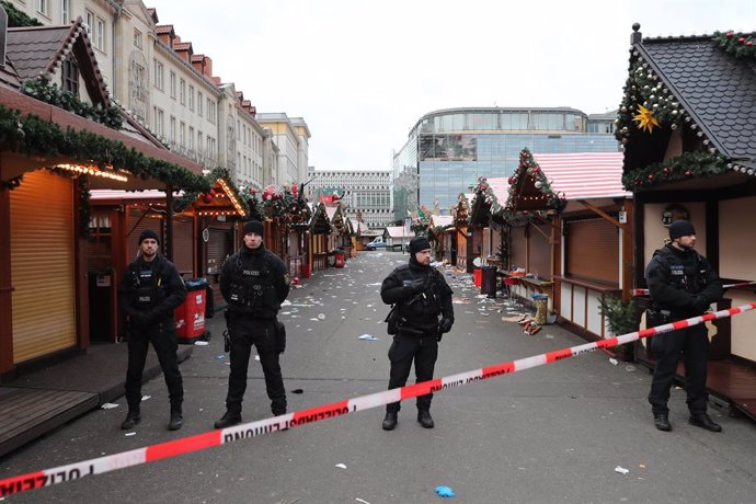 MAGDEBURG, Dec. 21, 2024  -- Policemen stand guard at a Christmas market where a car rammed into a crowd in Magdeburg, Germany, Dec. 21, 2024. At least five people were killed and over 200 others injured after a car rammed into a large crowd at a German C