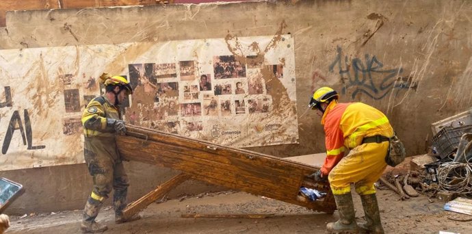 Efectivos de Sarga e Infoar colaboran para retirar una puerta de una calle de Catarroja.