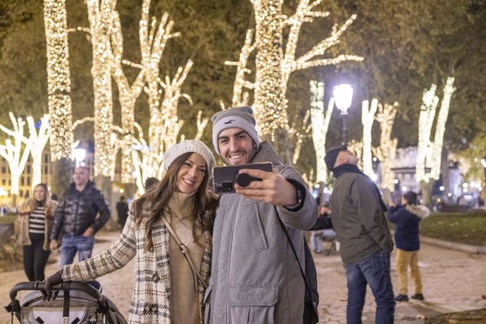 Archivo - Imagen de una pareja con un niño por las calles de Bilbao en periodo navideño.