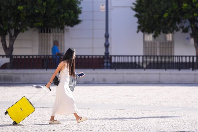 Archivo - Turista arrastra una maleta por una calle de Cádiz capital.