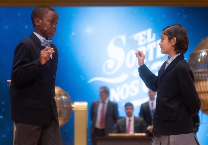 Ángel Abaga Elebiyo y Aurora Rodríguez Ososrio cantan un quinto premio, el número 72.853 durante la celebración del Sorteo Extraordinario de la Lotería de Navidad 2024, 