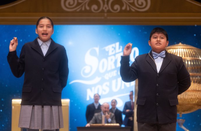 Piero Rai Chávez Huaroto y Alisce Ríos Gonzales cantan el primer premio, el 'Gordo', el número 72.480 durante la celebración del Sorteo Extraordinario de la Lotería de Navidad 2024, en el Teatro Real, a 22 de diciembre de 2024, en Madrid (España).