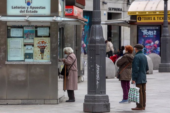 Archivo - Varias personas hacen cola en las inmediaciones de una administración de la Puerta del Sol donde venden boletos para el Sorteo Extraordinario de la Lotería de Navidad 2020, en Madrid (España), a 4 de noviembre de 2020. 