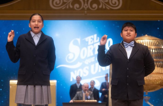 Piero Rai Chávez Huaroto y Alisce Ríos Gonzales cantan el primer premio, el 'Gordo', el número 72.480 durante la celebración del Sorteo Extraordinario de la Lotería de Navidad 2024, en el Teatro Real, a 22 de diciembre de 2024, en Madrid (España). El Esta