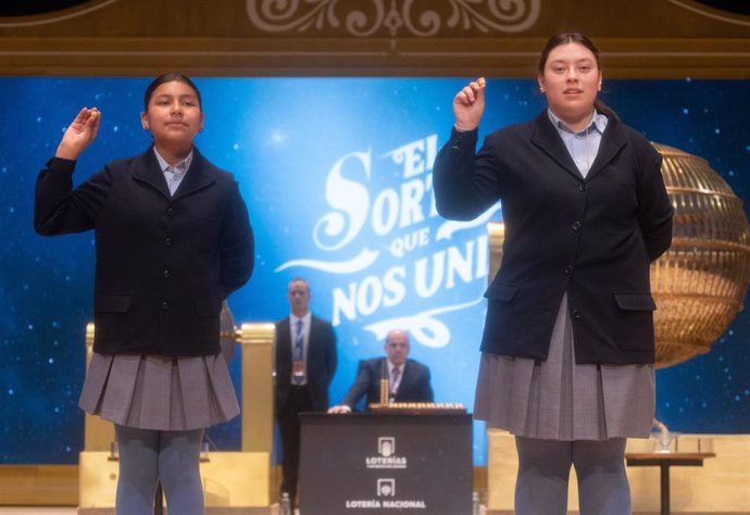 Yadira Quinde Mendoza (i) y Kiara Román Benítez (d), cantan un quinto premio, el número 45.225 durante la celebración del Sorteo Extraordinario de la Lotería de Navidad 2024, en el Teatro Real