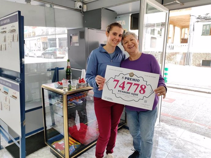 La propietaria del local de s'Arenal, Cati Coll, junto a su nuera (empleada, además, del establecimiento) posan tras haber vendido el 74.778, el tercero de los ocho quintos premios del Sorteo Extraordinario de Lotería de Navidad