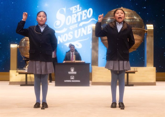 Aisha Solange Hurtado Auqui (i) y Alba Yadira Machaca Tapia (d) cantan el segundo premio, el número 40.014 durante la celebración del Sorteo Extraordinario de la Lotería de Navidad 2024, en el Teatro Real, a 22 de diciembre de 2024, en Madrid (España). El