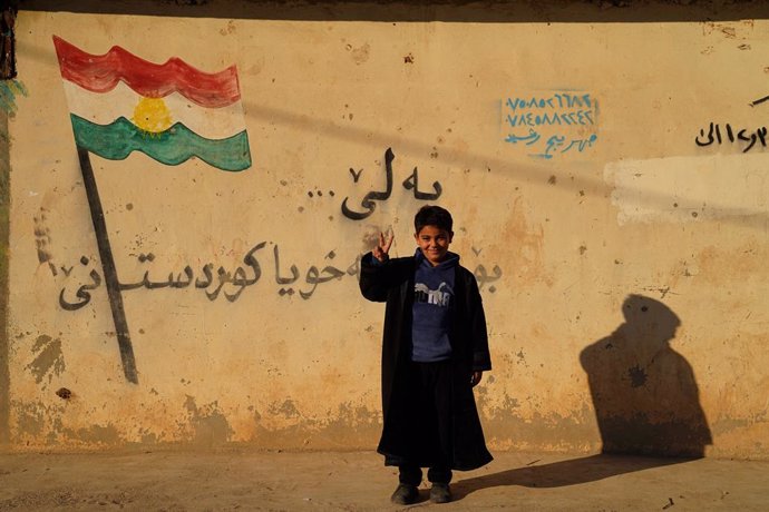 December 19, 2024, Damascus, Duhok, Iraq: A boy stands infront of the Kurdish flag at Domiz camp for Syrian Kurdish refugees about 18km southwest of Duhok city in the Kurdistan Region. Duhok province hosts 92,000 Syrian refugees out of 275,000 refugees in