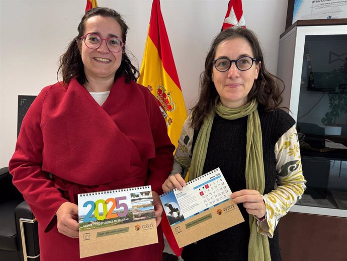 Patricia Rivera y Ana Adán con el calendario que reparte el Ayuntamiento de Binéfar