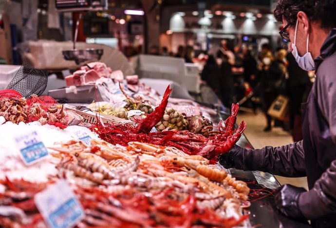 Archivo - Un vendedor en un puesto de marisco, en el Mercado Central de Valencia 