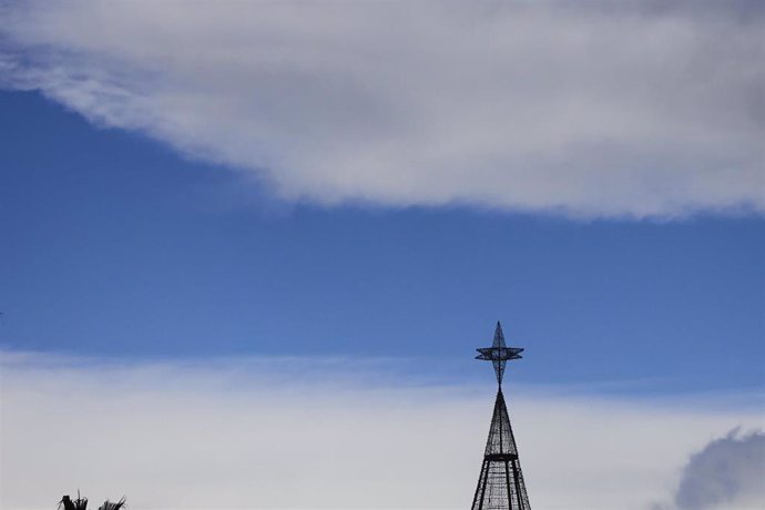 Archivo - Detalle del cielo con la punta de un árbol de Navidad 