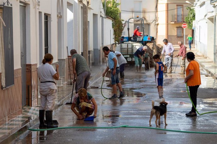 Archivo - Imagen de archivo de vecinos de Marinaleda (Sevilla) de limpieza en sus calles tras una lluvia torrencial de octubre de 2022.