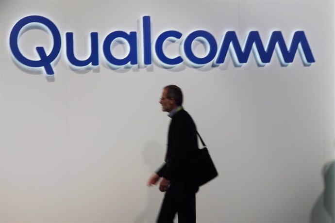 Archivo - FILED - 09 January 2019, US, Las Vegas: Visitors to the CES electronics trade fair walk past a Qualcomm logo. Photo: Christoph Dernbach/dpa