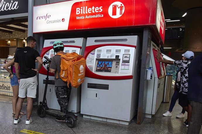 Archivo - Varias personas en una máquina de venta de billetes en la estación Madrid-Atocha Cercanías