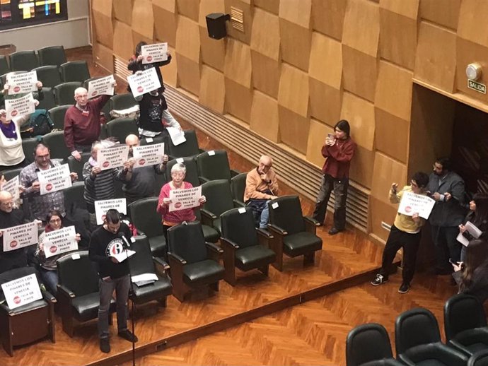 Representantes de entidades vecinales en el pleno del Ayuntamiento de Zaragoza han portado pancartas con el lema "Salvemos los pinares de Venecia. Stop a la tala de pinos".