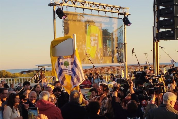 El cantante isleño Manuel Carrasco descubre la placa con la avenida que lleva su nombre en la barriada de Punta del Caimán, en Isla Cristina (Huelva).