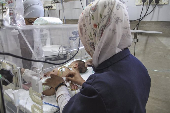 Archivo - Una trabajadora sanitaria atiende a un bebé con desnutrición en el Hospital Kamal Aduan, en Beit Lahia, en el norte de la Franja de Gaza (archivo)