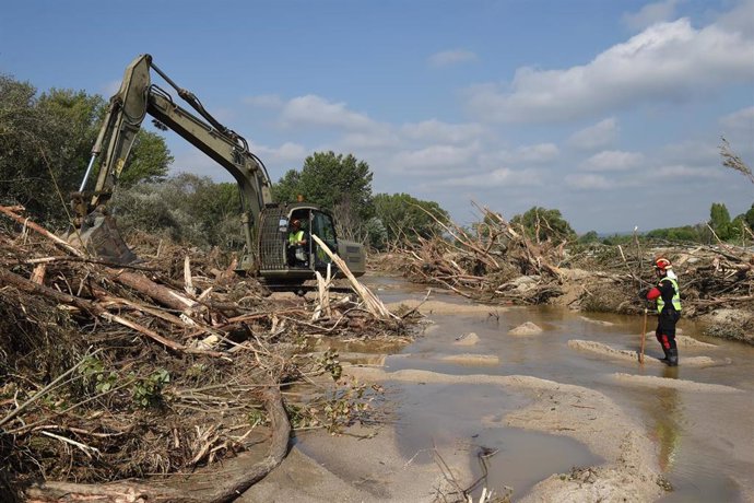 Archivo - Una máquina excavadora y un trabajador durante el dispositivo de búsqueda de los desaparecidos por las lluvias de La Dana.