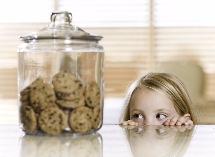 Archivo - Imagen de archivo de una niña mirando unas galletas.