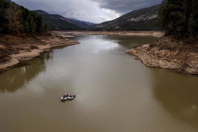 Una lancha trabaja para limpiar el agua tras el efecto de la DANA en la presa de Buseo, a 11 de diciembre de 2024, en Chera, Valencia, Comunidad Valenciana (España). 