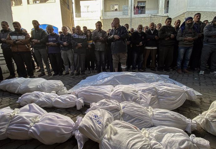 Palestinos rezan frente a varios muertos por los ataques de Israel contra la Franja de Gaza tras su traslado al Hospital Baptista Al Ahli, en la ciudad de Gaza (archivo)