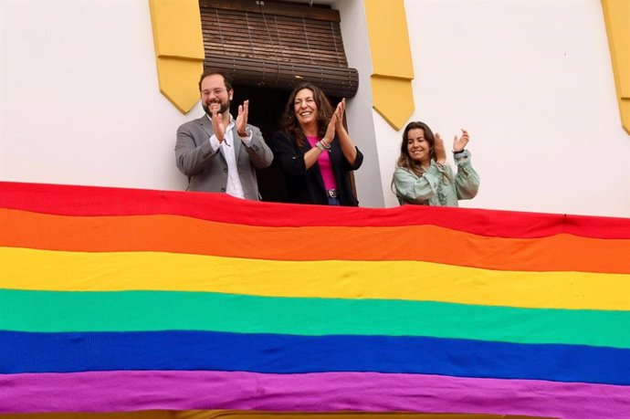 Archivo - La consejera de Inclusión Social, Loles López, en el Ayuntamiento de Beas (Huelva) en el despliegue de una bandera LGTBI.