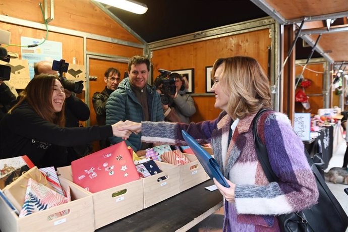 La ministra de Educación, Formación Profesional y Deportes, Pilar Alegría (d), durante su visita a la VIII edición de ‘Libros que importan’, en la Plaza del Pilar, a 27 de diciembre de 2024, en Zaragoza