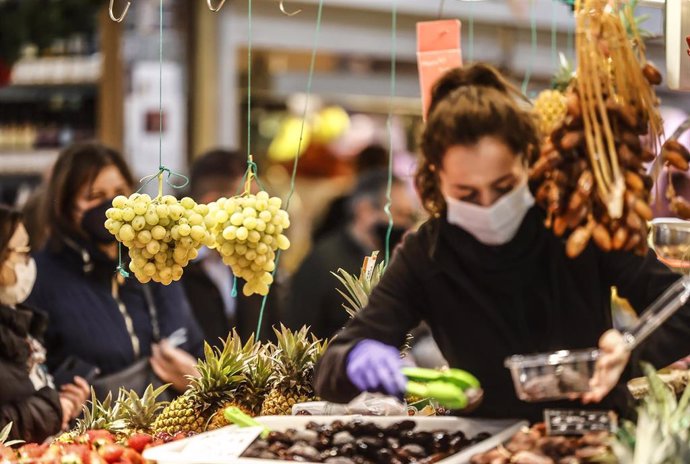 Archivo - Una vendedora en un puesto de fruta en el Mercado Central de Valencia.