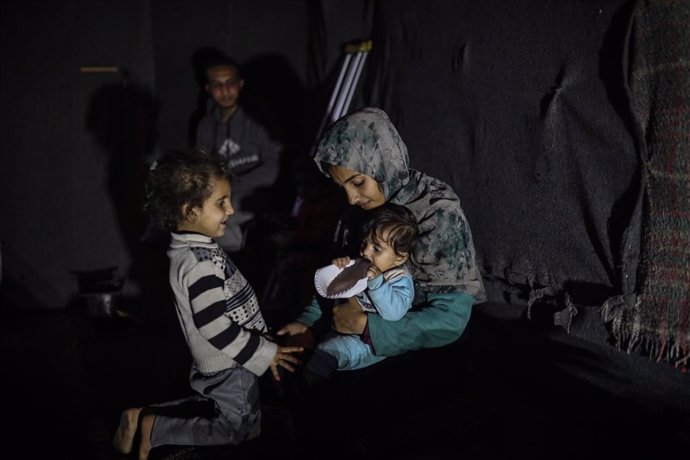 23 December 2024, Palestinian Territories, Deir El-Balah: Riyad Abu Sharkh, 26 years old, sits with his family inside his tent in a camp for displaced people in Deir al-Balah. Abu Sharkh lost one of his legs in an Israeli airstrike on the displaced people