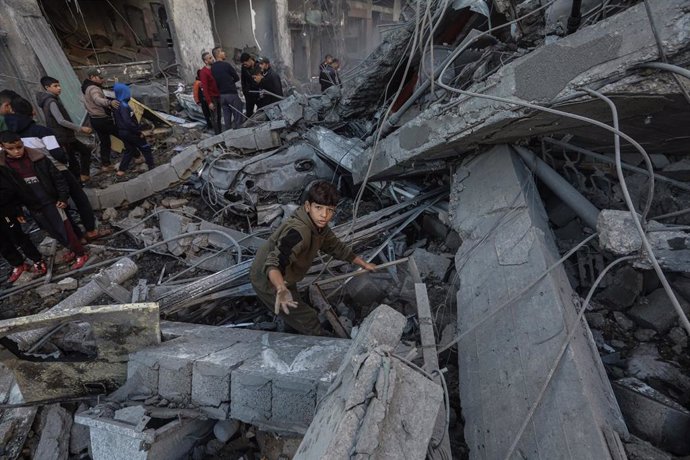 Palestinos inspeccionan escombros en un edificio tras un ataque israelí en la Franja de Gaza