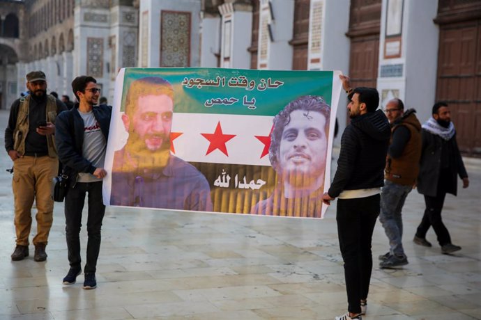 December 9, 2024: Damascus, Syria. 09 December 2024. A poster of the Syrian opposition flag with the image of HTS leader Abu Mohammed al-Jolani is displayed in the courtyard of the Omayyad Mosque in Damascus in the aftermath of the fall of the government 