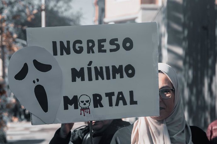 Una mujer sujeta un cartel de protesta durante una concentración convocada por la plataforma RMI Tu Derecho (Renta Mínima de Inserción), frente al Ministerio de Inclusión, Seguridad Social y Migraciones, a 28 de diciembre de 2024, en Madrid (España). El m