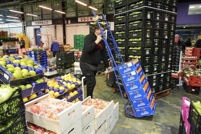 Archivo - Una trabajador desplaza una carretilla con cajas en Mercabilbao