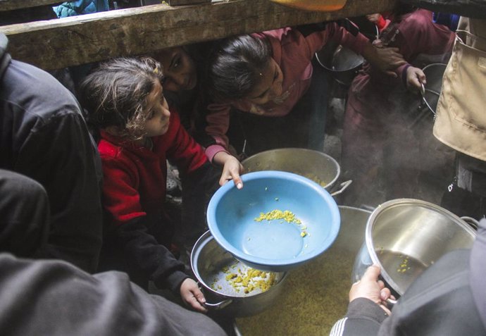 December 27, 2024, Gaza City, The Gaza Strip, Palestine: People try to receive food relief at a food distribution center in Gaza City.