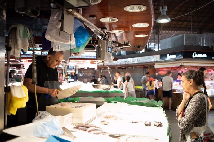 Archivo - Personas comprando en un mercado