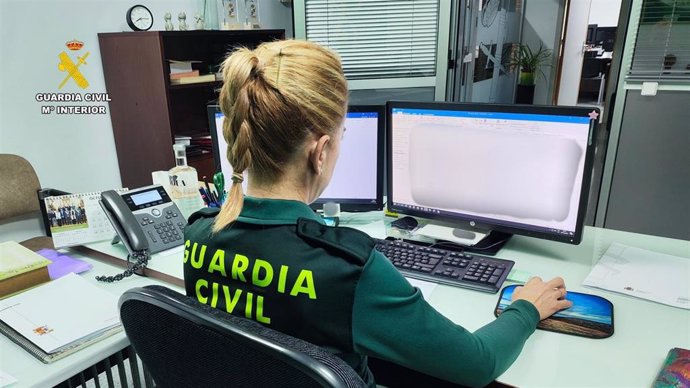 Archivo - Una agente de Guardia Civil delante de un equipo informático.