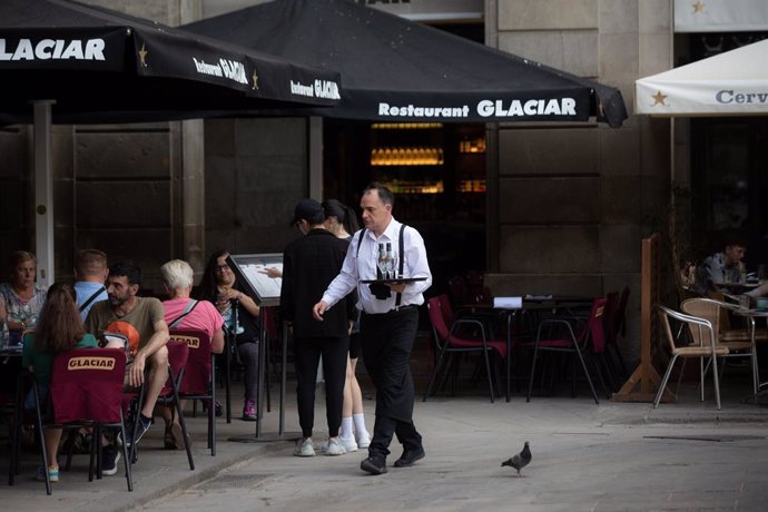 Archivo - Un camarero sostiene una bandeja en la plaza Real de Barcelona, a 15 de junio de 2022, en Barcelona, Catalunya (España). Los empresarios del turismo y la hostelería han reiterado la ausencia de trabajadores en su sector. Situación que ha sido pr