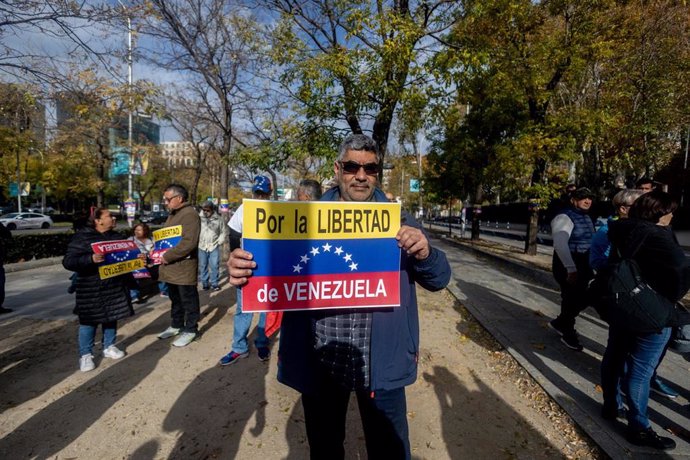 Un hombre sujeta un cartel de protesta durante una manifestación de venezolanos en Madrid