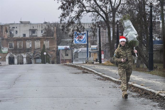 Un militar ucraniano porta un arbol de Navidad en Járkov