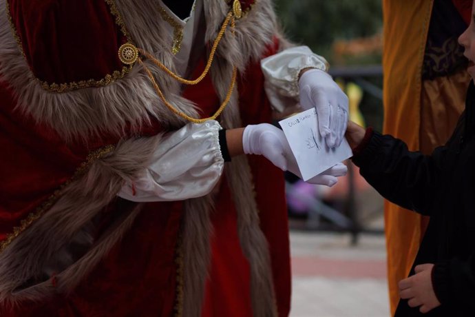 Archivo - Una niña entrega su carta a un Paje Real, en la Fundación Madrina, en la Plaza de San Amaro, a 15 de diciembre de 2023, en Madrid (España). La Fundación Madrina celebra estas Navidades distintos eventos bajo el lema ‘Mágica Navidad, convirtiendo