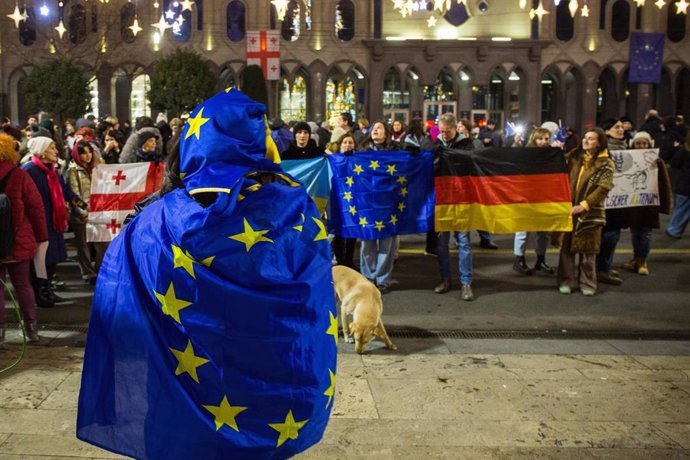 December 26, 2024, Tbilisi, Georgia: Protesters march with flags during the protest against the suspension of the country's accession negotiations with the European Union.