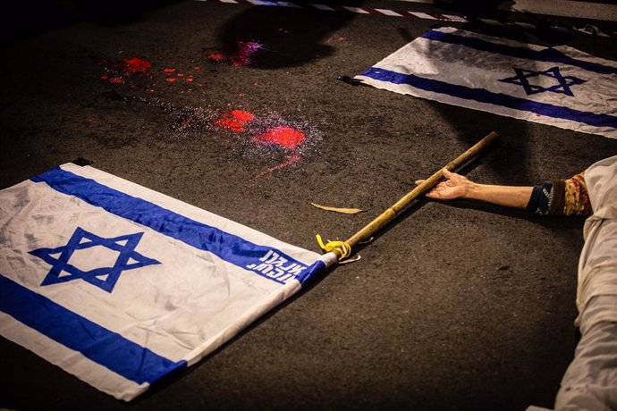 December 21, 2024, Tel Aviv, Israel: A protestor holds an Israeli flag during a protest in Tel Aviv. On Saturday, thousands took to the streets across Israel calling on the current government led by Prime Minister Benjamin Netanyahu to reach a hostage dea