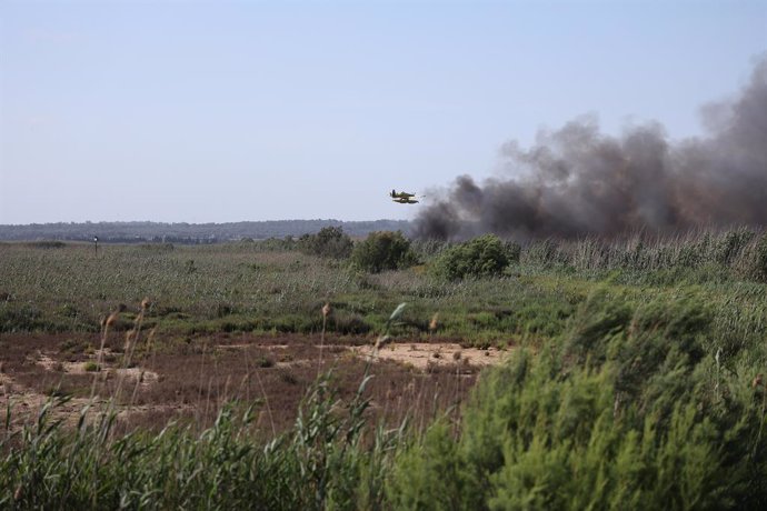 Archivo - Un helicóptero sobrevuela la zona afectada por un incendio.